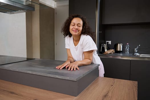 Authentic portrait of African American pretty woman at home, smiling, enjoying a happy weekend at home, dressed in white pajamas. People. Lifestyle. Domestic life. Leisure activity.