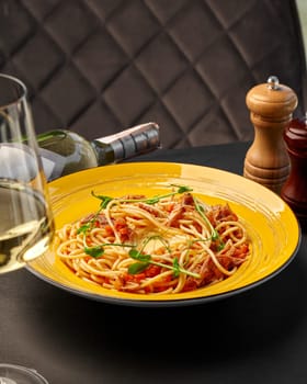 Al dente pasta with piquant duck ragu with vegetables, drizzled with creamy cheese sauce, presented on vibrant yellow plate, accompanied by delicate white wine. Italian cuisine