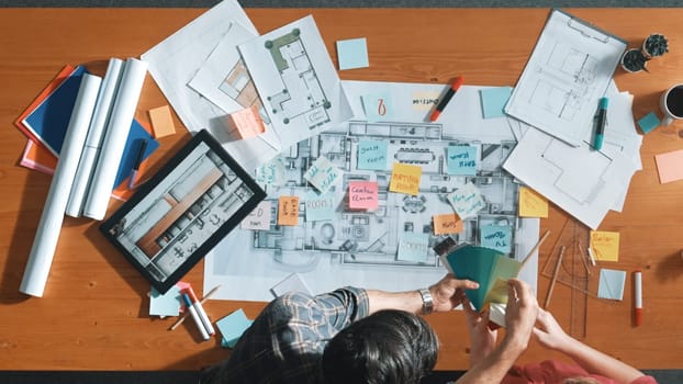 Top view of engineer working together to design building construction while standing at meeting table with blueprint and notes. Top view of interior designer choosing color from palettes. Symposium.