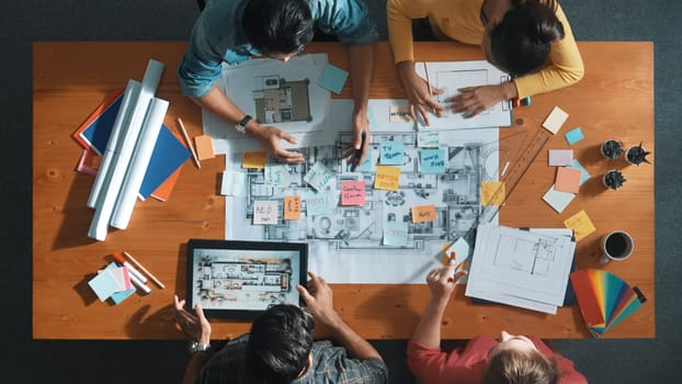 Top view of civil engineer discussing about house construction while planning about building design at meeting table with blueprint and architectural equipment. Design brainstorming idea. Symposium.