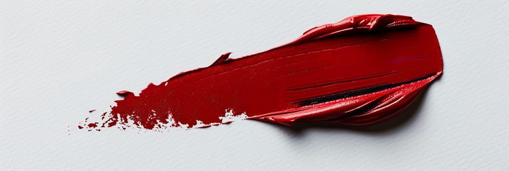 A classic red lipstick smudge on a pristine white surface, creating a bold and striking contrast.