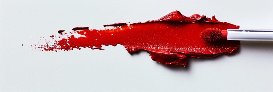 A close-up of a red lipstick brush creating a bold swatch on paper, showcasing the intense hue of classic matte red lipstick.