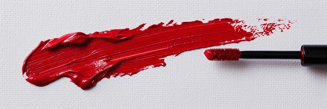 Red lipstick leaves a striking swatch on white surface, creating a dramatic and alluring scene.