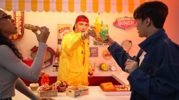 Multicultural skilled customer clinking glasses together to celebrate successful project. Restaurant worker dancing while holding glass with juice and milkshake clink glasses with friend. Regalement.