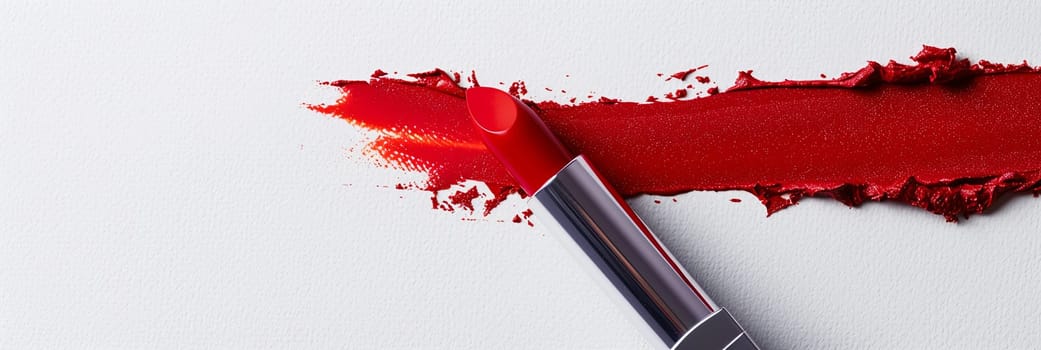 A vibrant red lipstick leaves a bold swatch on a pristine white surface.