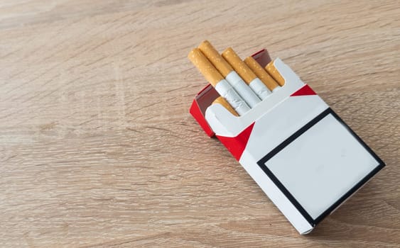 Pack of cigarettes on wooden textured table. High quality photo