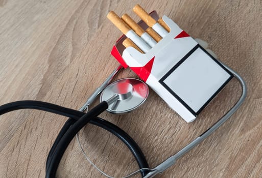 Cigarettes and stethoscope on insurance documents. High quality photo