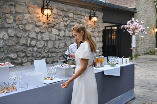 Woman taking food snacks at buffet at a wedding