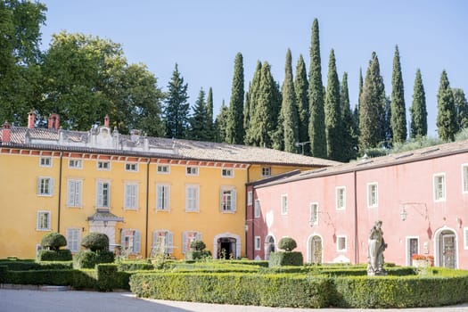 Neatly trimmed bushes with sculptures in the garden in front of the ancient Villa Cordevigo. Verona, Italy. High quality photo