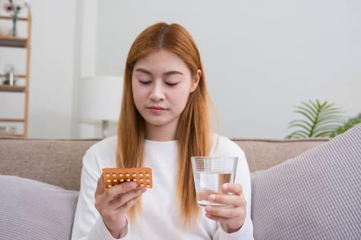 A young woman with a birth control pills reads instructions on how to use them correctly..