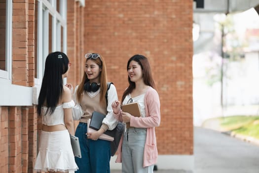 Students socializing outside a school building. Group of young friends talking and laughing on campus. Concept of education, friendship, and student life.