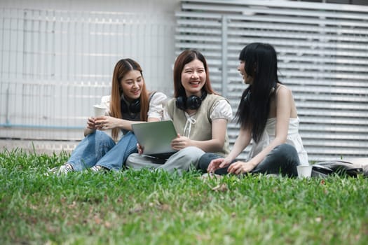 University students studying and laughing together on campus lawn. Group of young friends enjoying outdoor learning and bonding. Concept of education, friendship, and student life.