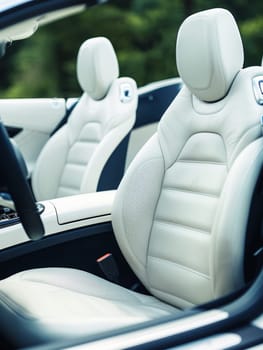 The interior of a convertible car boasts plush white seats and a sleek design, perfect for an enjoyable ride with the top down