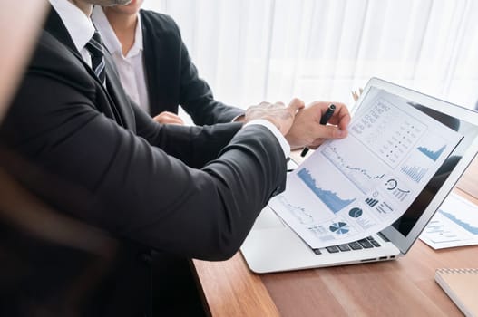 Diverse group of business analyst team analyzing financial data report paper on office table. Chart and graph dashboard by business intelligence analysis for strategic marketing planning Habiliment