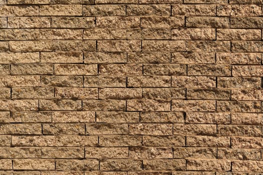 Close-up view of a textured brick wall, showcasing the intricate patterns and details of individual stones creating an abstract composition.