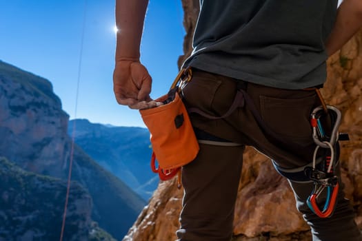 Male hand with magnesia powder close-up, against the background of beautiful mountains, the hand of climber who prepares for training outdoors, a man climbs in Twin Caves, Greece on a sunny day.