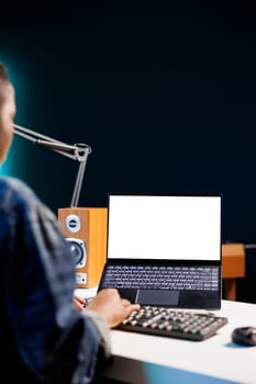 Black woman working from home at a desk with wireless computer displaying an isolated white screen. African american person using digital laptop showing blank chromakey mockup template.