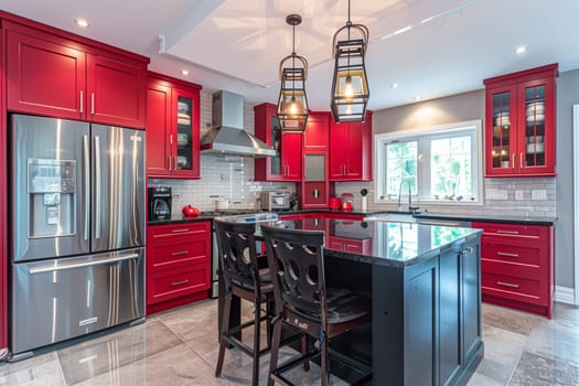 A modern kitchen featuring bright red cabinets and a spacious center island for food preparation and dining.
