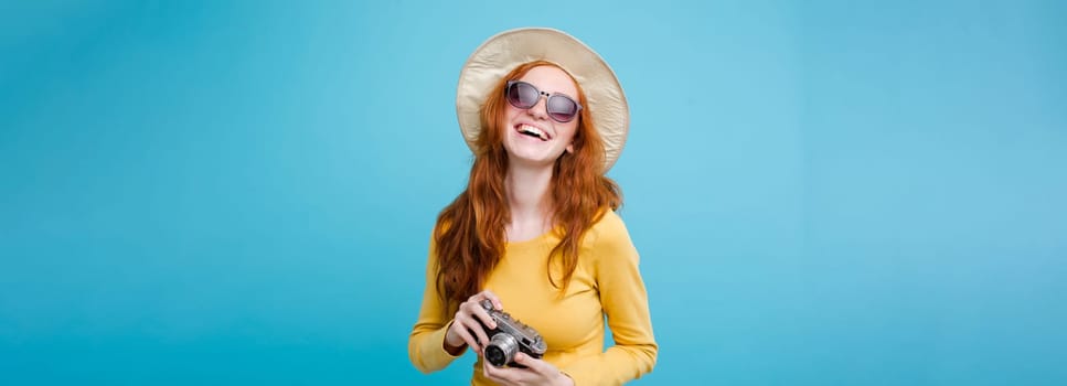 Travel concept - Close up Portrait young beautiful attractive redhair girl wtih trendy hat and sunglass smiling. Blue Pastel Background. Copy space.