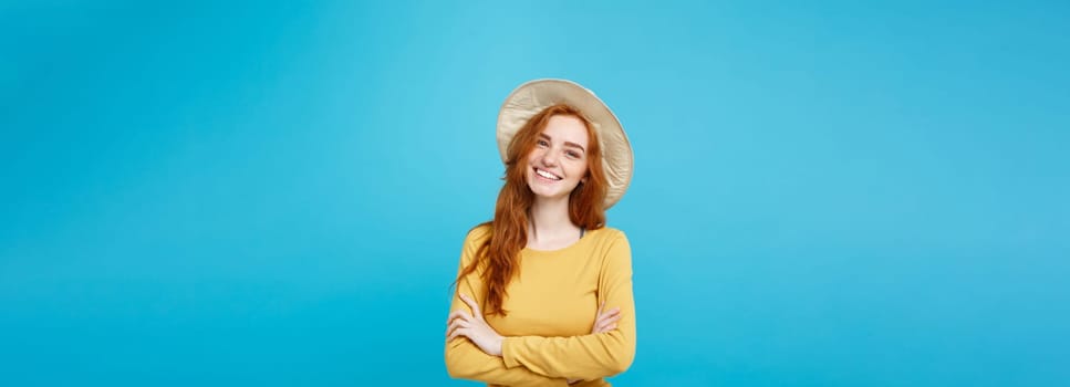 Travel concept - Close up Portrait young beautiful attractive ginger red hair girl with trendy hat and smiling. Blue Pastel Background. Copy space