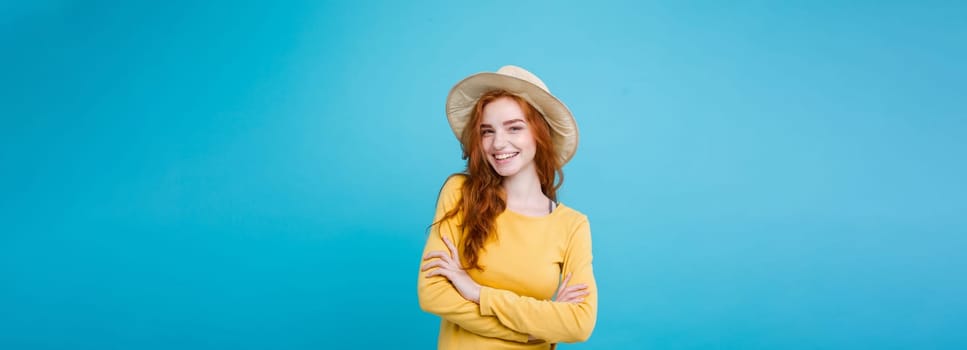 Travel concept - Close up Portrait young beautiful attractive redhair girl wtih trendy hat and sunglass smiling. Blue Pastel Background. Copy space.