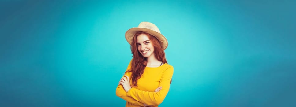 Travel concept - Close up Portrait young beautiful attractive redhair girl wtih trendy hat and sunglass smiling. Blue Pastel Background. Copy space.