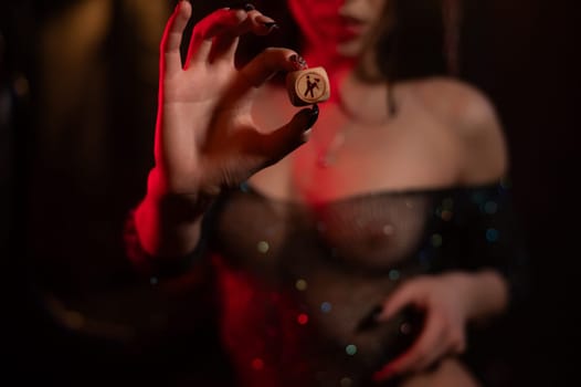 Seductive woman dressed in erotic fishnet holding dice with sex positions