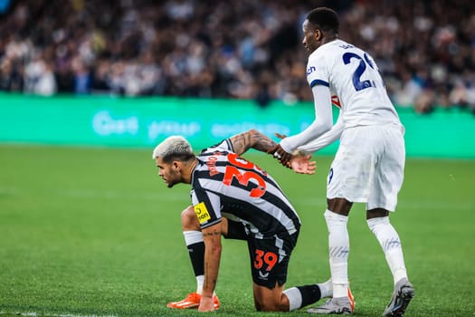 MELBOURNE, AUSTRALIA - MAY 22: Pape Matar Sarr of Tottenham Hotspur helps up Bruno Guimaraes of Newcastle United during the Global Football Week at The Melbourne Cricket Ground on May 22, 2024 in Melbourne, Australia