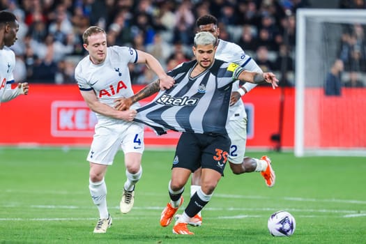 MELBOURNE, AUSTRALIA - MAY 22: Oliver Skipp of Tottenham Hotspur and Bruno Guimaraes of Newcastle United tussle for the ball during the Global Football Week at The Melbourne Cricket Ground on May 22, 2024 in Melbourne, Australia