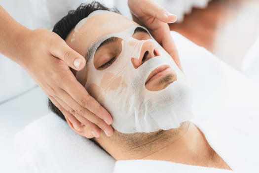 Serene modern daylight ambiance of spa salon, woman customer indulges in rejuvenating with facial skincare mask. Facial skin treatment and beauty cosmetology procedure for face. Quiescent