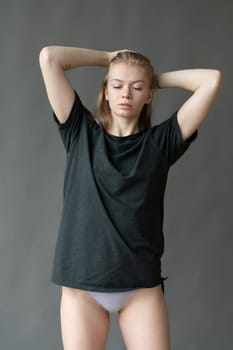 young beautiful woman posing in gray lingerie in studio