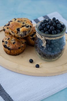 Homemade baked blueberry muffins with fresh harvested blackberries in glass jar. Tasty pastry sweet cupcake dessert. Berry pie Healthy vegan cupcakes with organic berries. Gluten free healthcare recipe from alternative flour