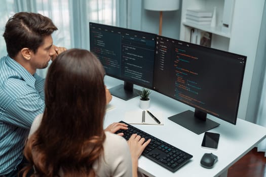Team skilled developers program coding discussing creative website planning software project on two screen monitor's full stack data analyzing design at office with back side view concept. Postulate.