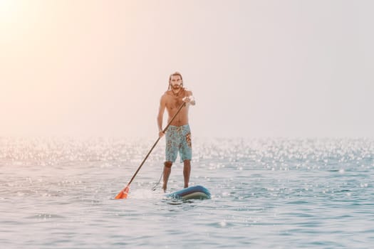 Man Sea Sup. Strong athletic man learns to paddle sup standing on board in open sea ocean on sunny day. Summer holiday vacation and travel concept. Aerial view. Slow motion.