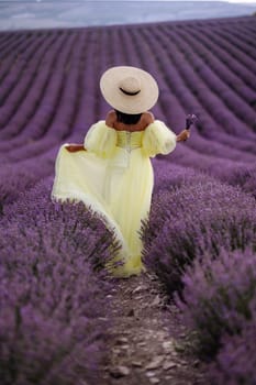 Woman lavender field. Lavender field happy woman in yellow dress in lavender field summer time. Aromatherapy concept, lavender oil, photo session in lavender.