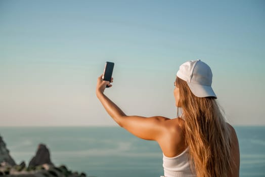 Selfie woman in cap and tank top making selfie shot mobile phone post photo social network outdoors on sea background beach people vacation lifestyle travel concept