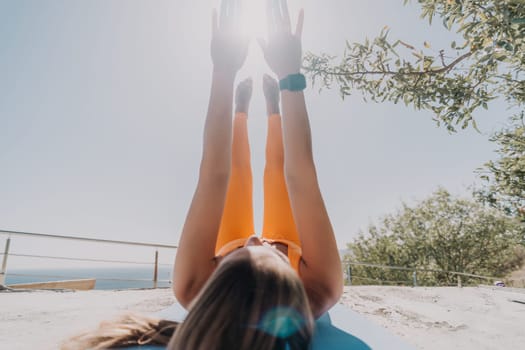 Fitness woman sea. Outdoor workout on yoga mat in park near to ocean beach. Female fitness pilates yoga routine concept. Healthy lifestyle. Happy fit woman exercising with rubber band in park.