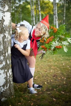 Young and adult schoolgirl on September 1, mother and daughter having fun and joy. Generations of schoolchildren of USSR and Russia. Female pioneer in red tie and October girl in modern uniform