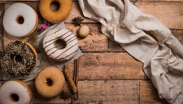 Variety of donuts over a rustic background shot from overhead 