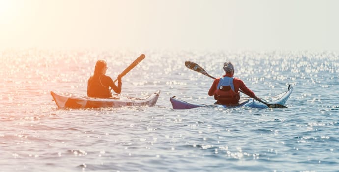 Happy smiling woman in kayak on ocean, paddling with wooden oar. Calm sea water and horizon in background