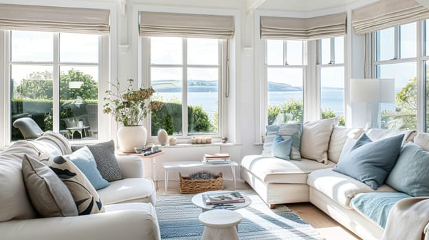 Interior of a living room with white walls, sofa and cushions. Sitting room in coastal cottage with sea view. Luxury lounge room