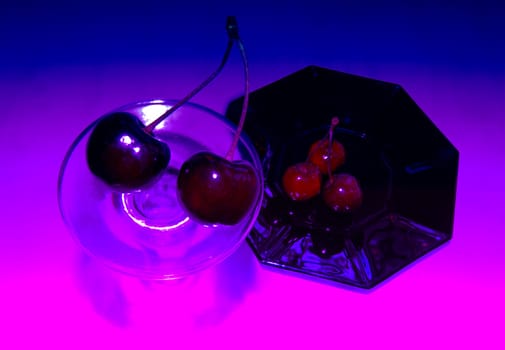 Ripe, delicious cherries.There is a red cherry on a black saucer.