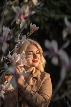 A woman is holding a magnolia flower in her hand and standing in front of a tree. Concept of serenity and beauty, as the woman is surrounded by nature and the flower adds a touch of color