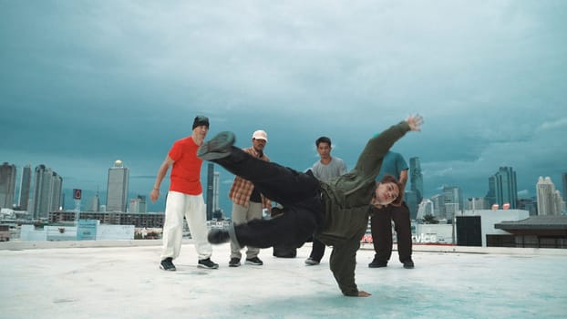 Hispanic hipster dancing surrounded by multicultural friend at city view with blue sky. Group of street dancer performing at rooftop. Active, fun, happy atmosphere. Outdoor sport 2024. Endeavor.