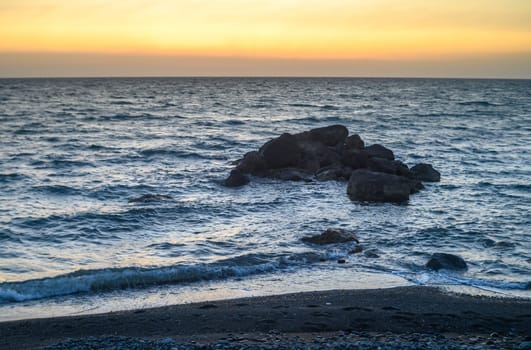 sunset view of stones in the Mediterranean sea near the beach of Cyprus