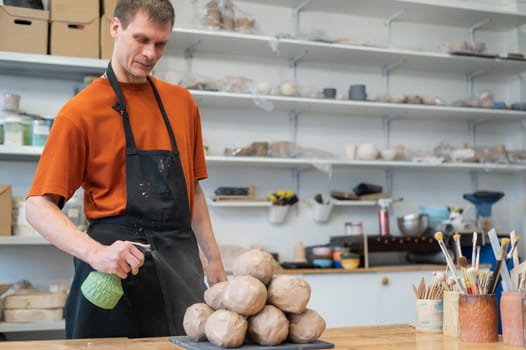 The potter wets the clay before using it in the workshop