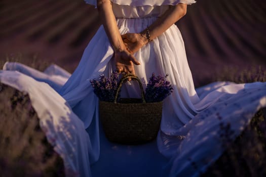 Back view woman lavender sunset. Happy woman in white dress holds lavender bouquet. Aromatherapy concept, lavender oil, photo session in lavender.