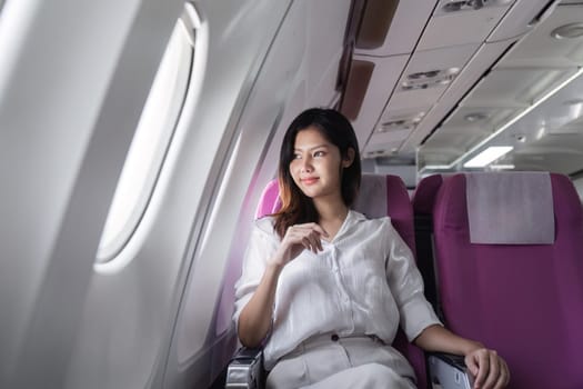 Businesswoman smiling while sitting in airplane seat. Concept of business travel and professional journey.