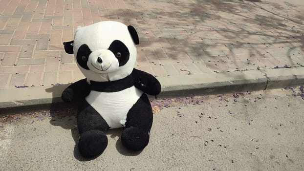 large soft children's toy panda bear thrown out on the street. High quality photo