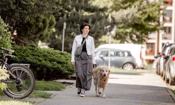 Young Woman With Golden Retriever Enjoys Summer Walk